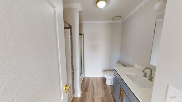 bathroom featuring toilet, ornamental molding, vanity, a shower with door, and hardwood / wood-style flooring