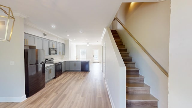 kitchen with gray cabinets, sink, ornamental molding, black appliances, and light hardwood / wood-style flooring