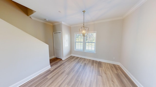 unfurnished room featuring an inviting chandelier, light hardwood / wood-style flooring, and ornamental molding