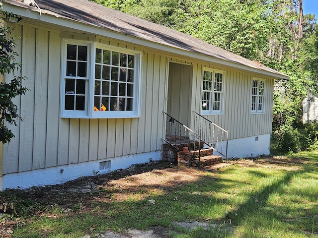 view of front facade featuring crawl space, roof with shingles, a front yard, and entry steps