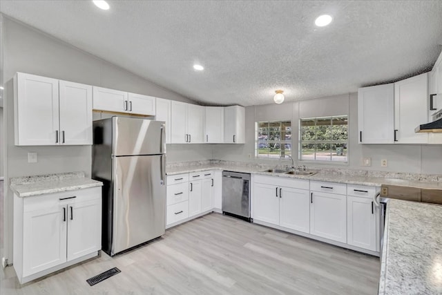 157 Quail Rdg, Moultrie, GA 31788 - kitchen featuring appliances with stainless steel finishes, a sink, a textured ceiling, white cabinetry, and vaulted ceiling