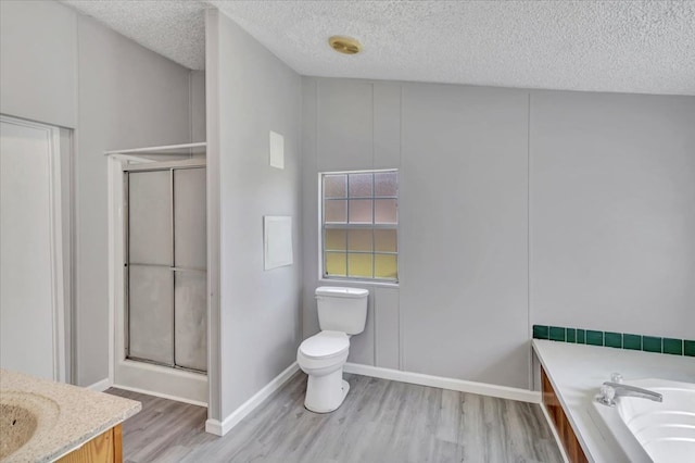 157 Quail Rdg, Moultrie, GA 31788 - bathroom with wood finished floors, a shower stall, toilet, a textured ceiling, and a bath