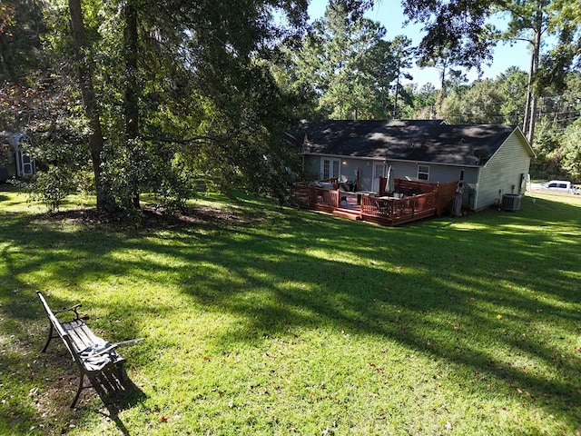 view of yard with a wooden deck and central air condition unit