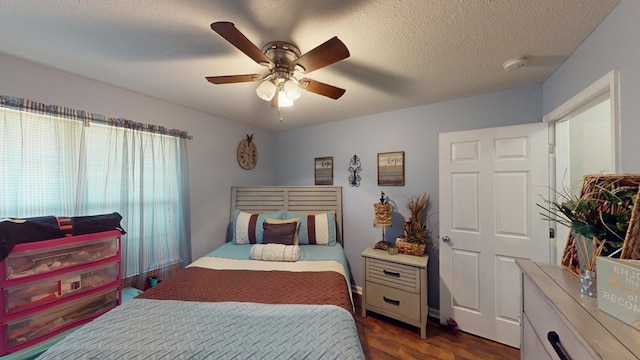 bedroom with ceiling fan, dark hardwood / wood-style floors, and a textured ceiling