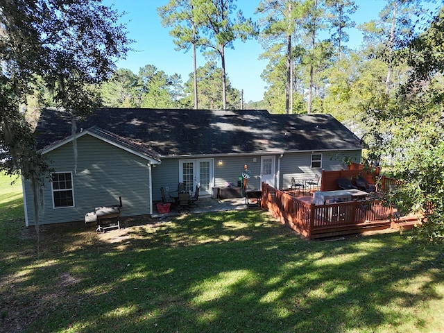 back of house with french doors, a wooden deck, and a lawn