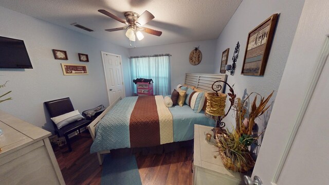 bedroom featuring ceiling fan, dark hardwood / wood-style floors, and a textured ceiling