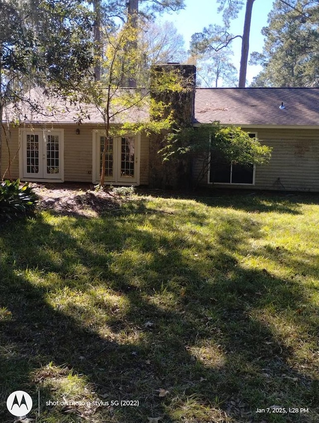 rear view of house featuring a yard and french doors