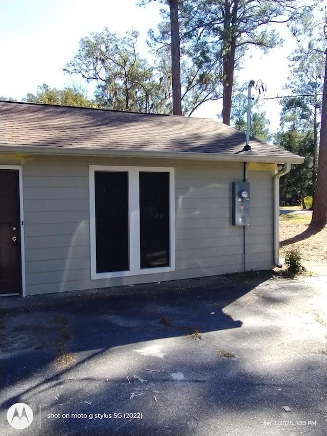 view of property exterior with a shingled roof