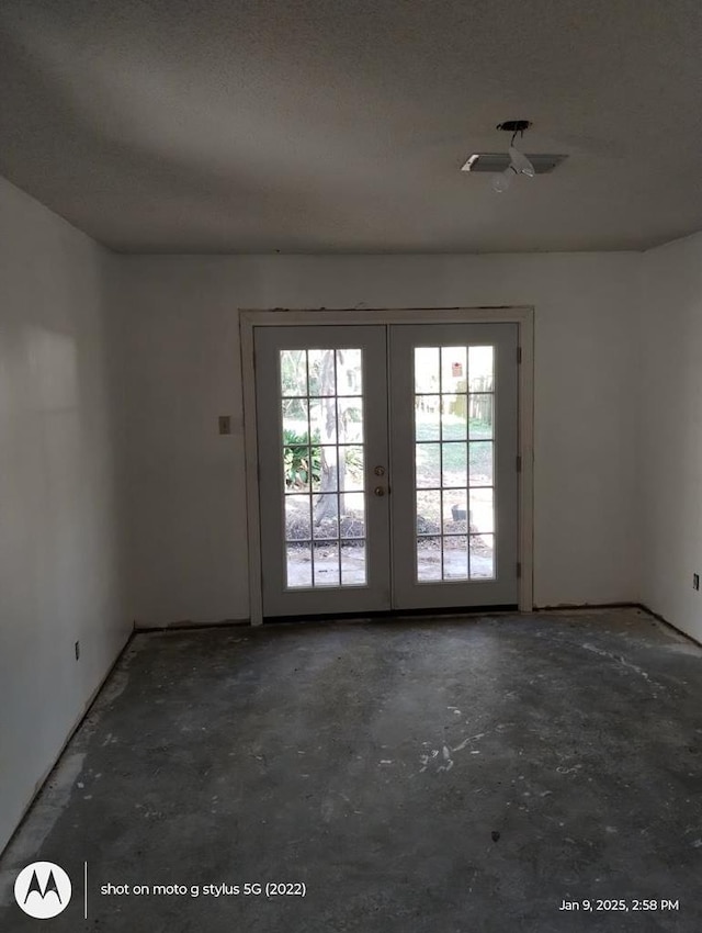 entryway with unfinished concrete floors and french doors