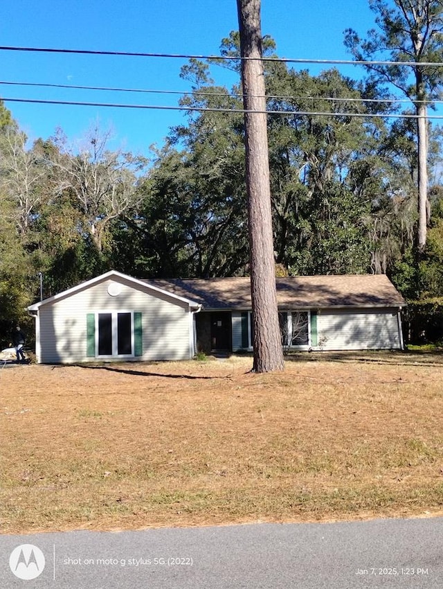 single story home featuring a garage and a front yard