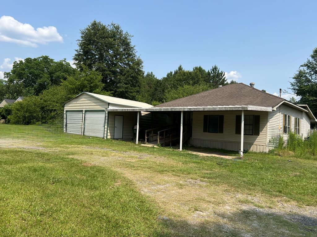183 Dean Mathews Rd, Moultrie, GA 31788 - rear view of property featuring a garage, a yard, and an outbuilding