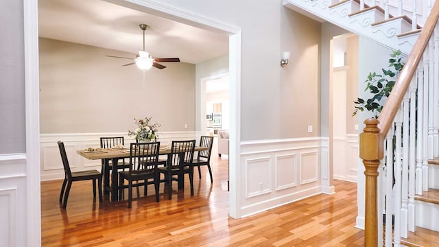200 Sawgrass Ln, Thomasville, GA 31757 - dining space with ceiling fan, stairs, light wood-type flooring, a decorative wall, and a wainscoted wall