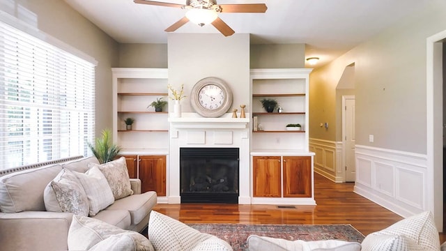 200 Sawgrass Ln, Thomasville, GA 31757 - living area featuring ceiling fan, dark wood-style flooring, a large fireplace, a wainscoted wall, and a decorative wall