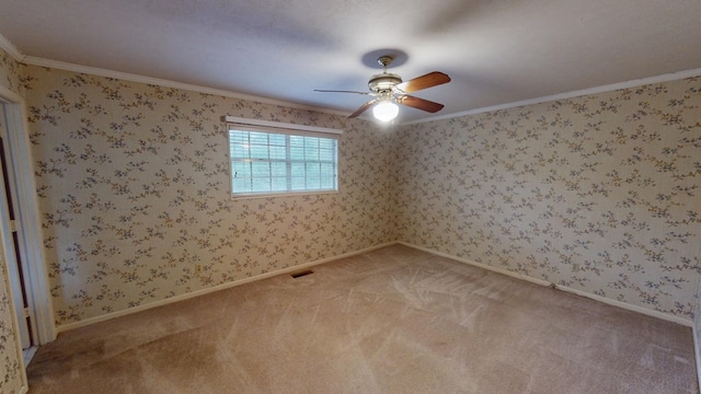 spare room featuring carpet floors, ornamental molding, and ceiling fan