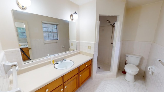 bathroom featuring tile walls, vanity, a tile shower, tile patterned floors, and toilet