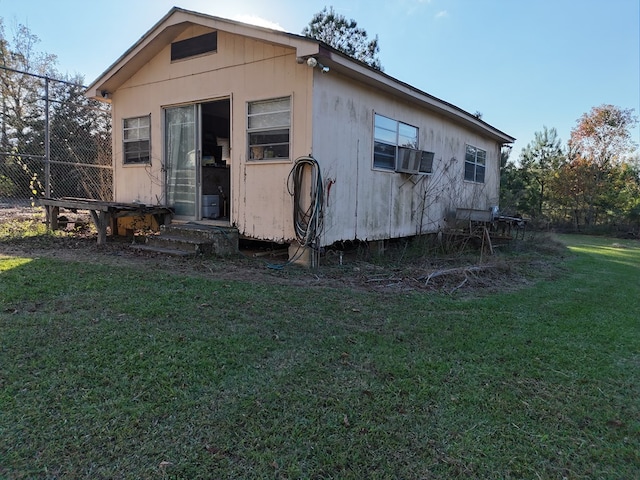 back of house featuring cooling unit and a lawn