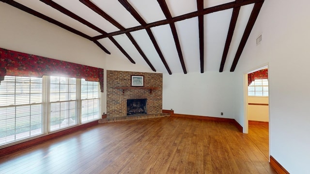 unfurnished living room with wood-type flooring, a fireplace, and a wealth of natural light