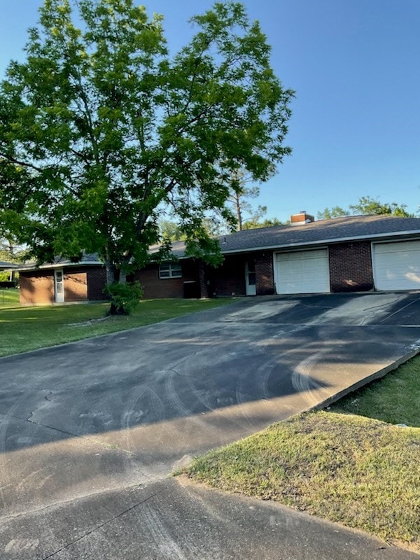 786 SW Madison Ln, Cairo, GA 39828 - single story home with aphalt driveway, a garage, a front lawn, and brick siding