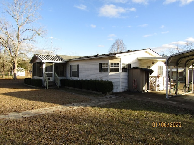 view of front of home with a sunroom and a carport