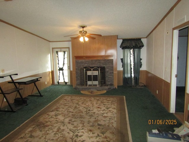 carpeted living room with crown molding, ceiling fan, and a fireplace