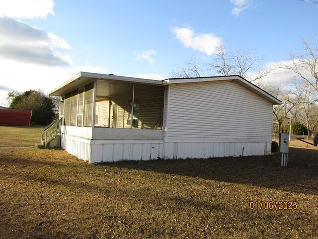 view of property exterior with a yard and a sunroom