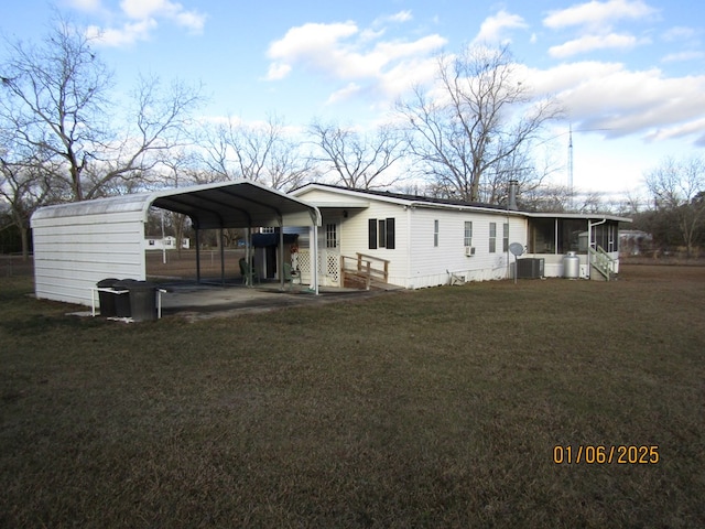 view of front of property with a carport, a sunroom, a front yard, and cooling unit