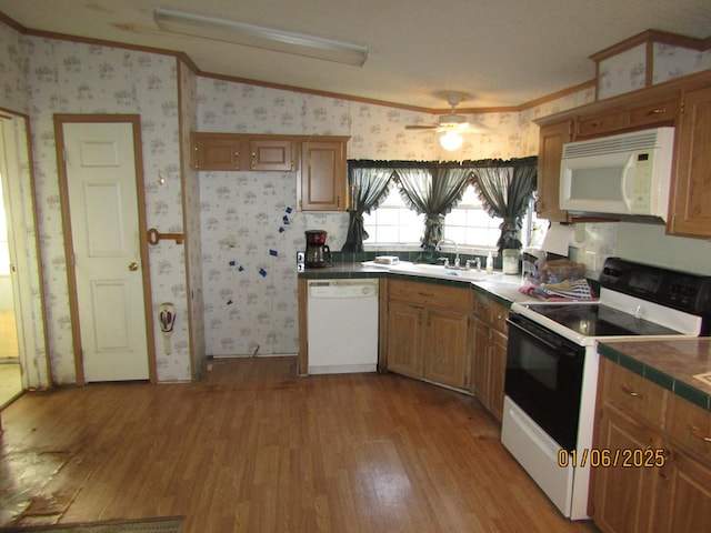 kitchen featuring sink, white appliances, ornamental molding, and light hardwood / wood-style floors