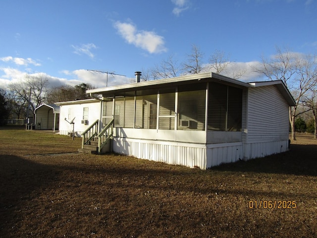 view of home's exterior with a sunroom and a lawn