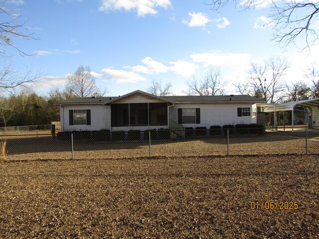 rear view of house with a sunroom and a carport