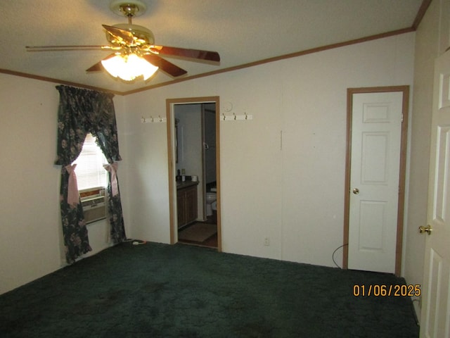 carpeted spare room featuring crown molding, ceiling fan, and vaulted ceiling