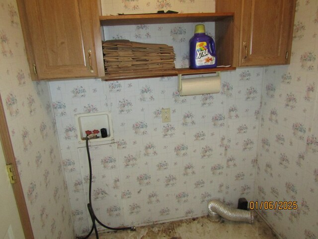 clothes washing area with cabinets and washer hookup