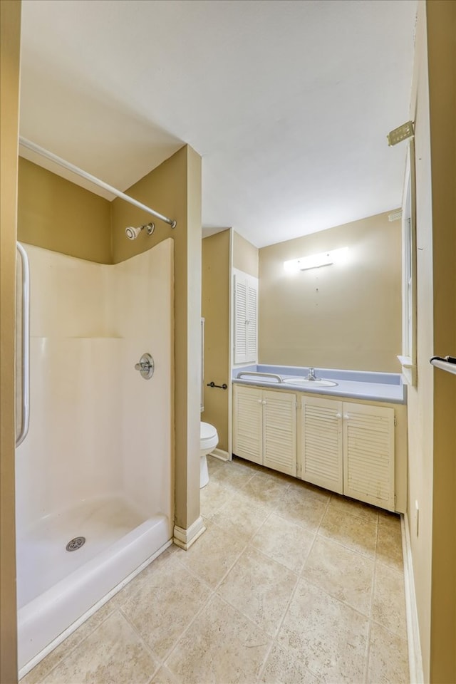 bathroom with vanity, a shower, tile patterned floors, and toilet