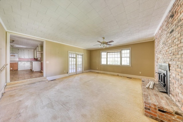 unfurnished living room featuring ceiling fan, light colored carpet, ornamental molding, and a brick fireplace