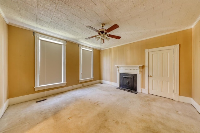 unfurnished living room featuring ornamental molding, carpet floors, and ceiling fan