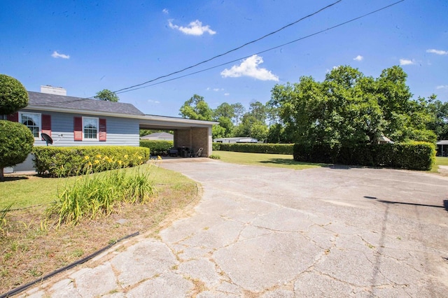 view of home's exterior featuring a carport and a yard