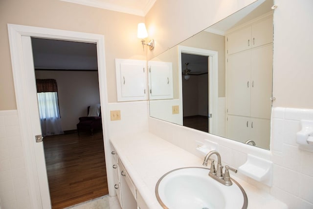 bathroom with hardwood / wood-style flooring, ornamental molding, and vanity