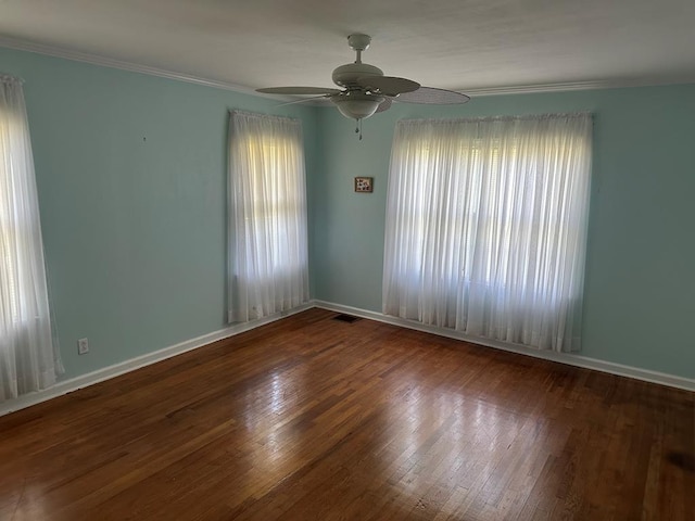 spare room featuring dark hardwood / wood-style flooring, ornamental molding, and ceiling fan