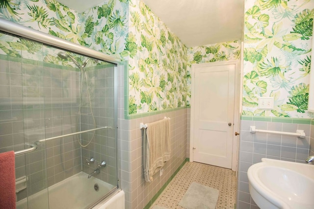 bathroom featuring tile walls, tile patterned flooring, and shower / bath combination with glass door