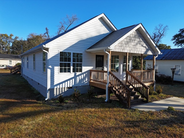 view of front of home featuring covered porch and a front lawn