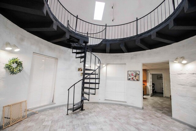 6715 Stewart Rd, Ochlocknee, GA 31773 - stairs with a towering ceiling, wood finished floors, and a skylight