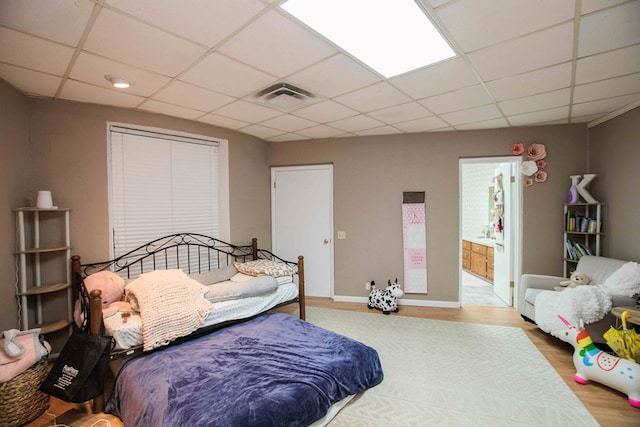 6715 Stewart Rd, Ochlocknee, GA 31773 - bedroom with a paneled ceiling, wood finished floors, baseboards, and ensuite bathroom