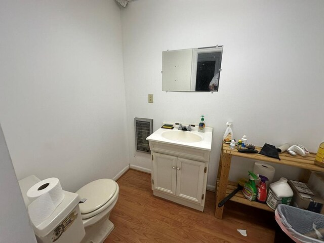 6715 Stewart Rd, Ochlocknee, GA 31773 - half bathroom featuring wood finished floors, toilet, vanity, and baseboards