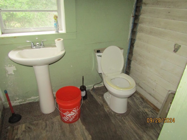 bathroom with toilet, hardwood / wood-style floors, and wood walls