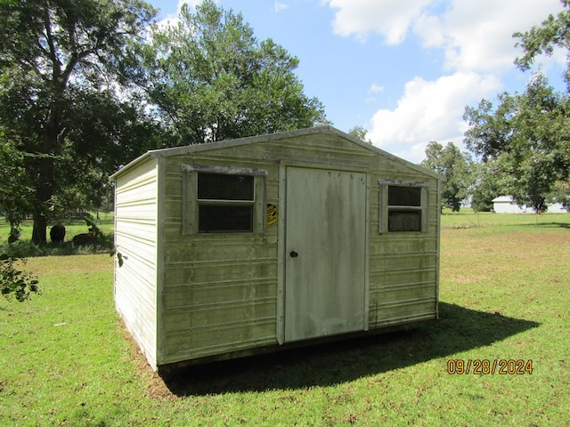 view of outbuilding featuring a yard