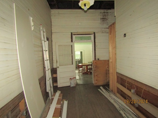 corridor featuring wooden walls