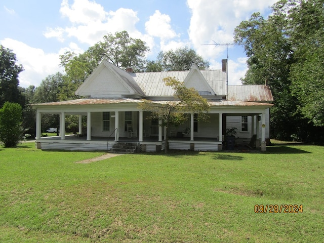 rear view of property featuring a lawn and covered porch