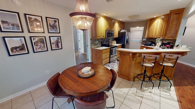 106 Hayden Way, Thomasville, GA 31792 - kitchen featuring stainless steel appliances, backsplash, a peninsula, baseboards, and light countertops