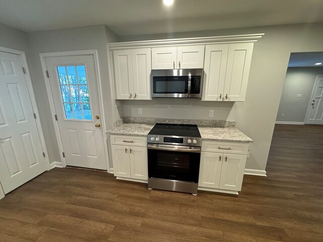 kitchen with dark wood-type flooring, light stone countertops, white cabinets, and appliances with stainless steel finishes