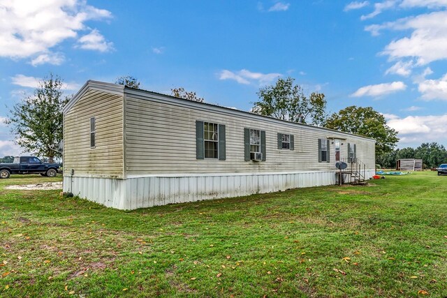 view of side of home featuring cooling unit and a lawn