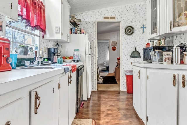 kitchen featuring ornamental molding, dark hardwood / wood-style floors, a textured ceiling, and white cabinets